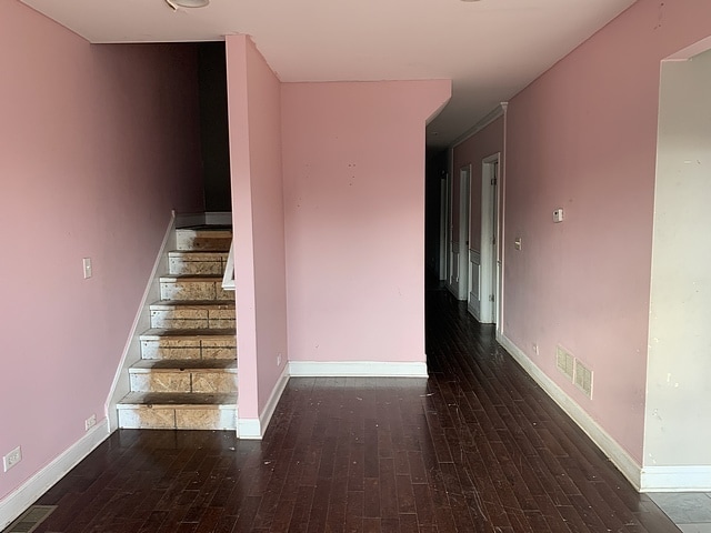 staircase featuring visible vents, baseboards, and wood finished floors