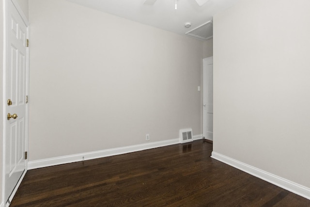 unfurnished room featuring visible vents, dark wood-type flooring, ceiling fan, baseboards, and attic access