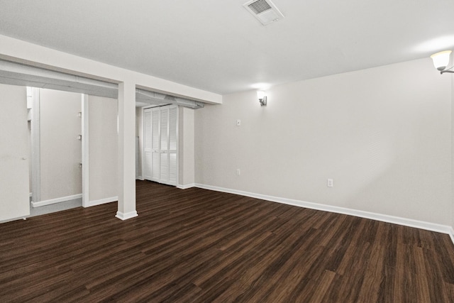 finished below grade area with visible vents, baseboards, and wood finished floors