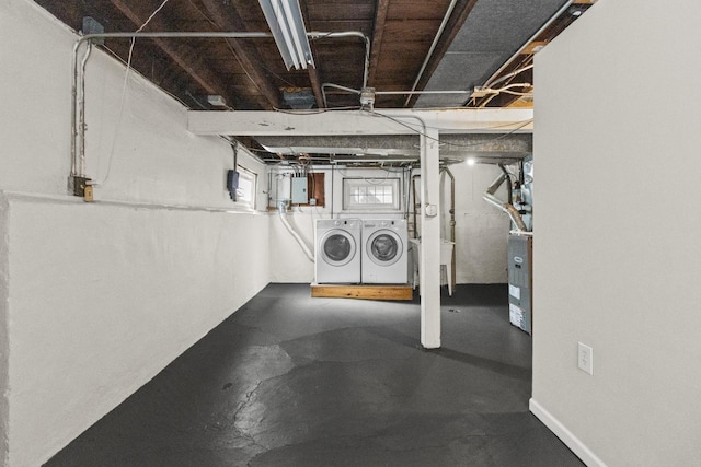 basement with a sink, electric panel, and washer and clothes dryer