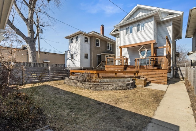 back of house featuring a deck and a fenced backyard