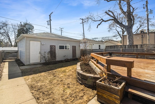 view of yard featuring an outbuilding, a deck, and fence