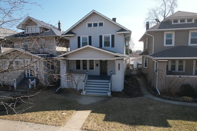 traditional style home with covered porch and a front lawn