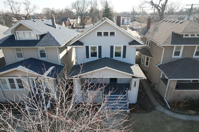 exterior space featuring a residential view and a shingled roof