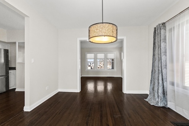 unfurnished dining area featuring visible vents, baseboards, and wood finished floors