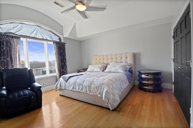 bedroom featuring visible vents, ceiling fan, baseboards, vaulted ceiling, and light wood-style floors