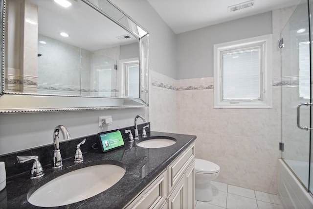 full bathroom with a sink, visible vents, toilet, and tile walls