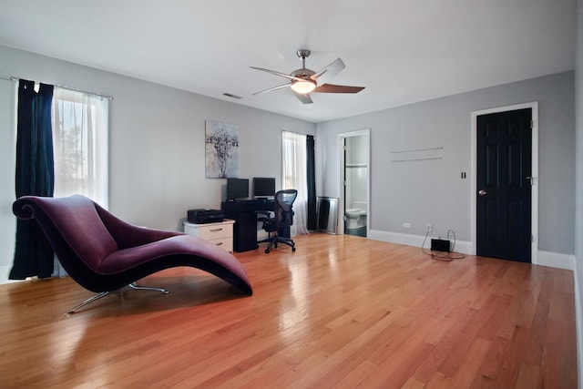 home office featuring light wood-style flooring, baseboards, visible vents, and ceiling fan