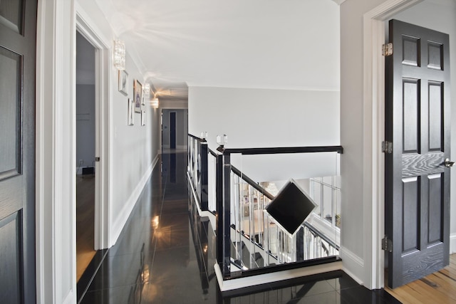 hallway with baseboards and an upstairs landing