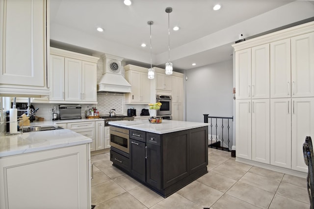 kitchen with dark cabinetry, recessed lighting, premium range hood, and stainless steel appliances