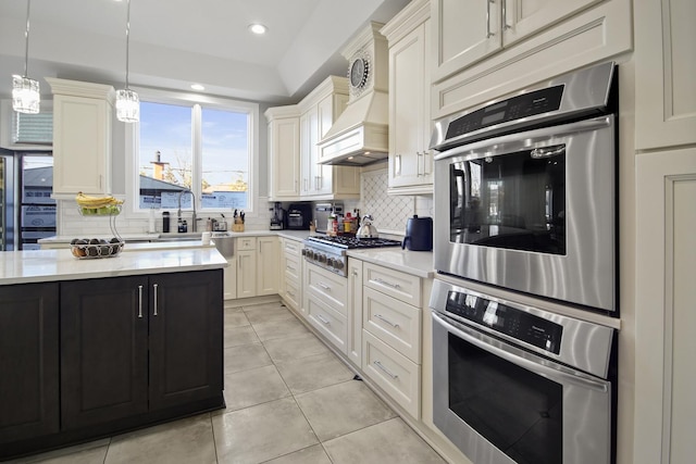 kitchen featuring hanging light fixtures, stainless steel gas stovetop, light tile patterned floors, and backsplash