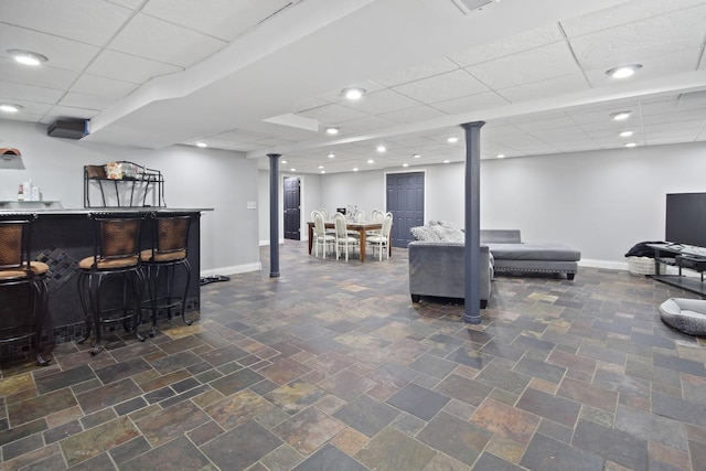 interior space featuring a dry bar, recessed lighting, baseboards, and a drop ceiling