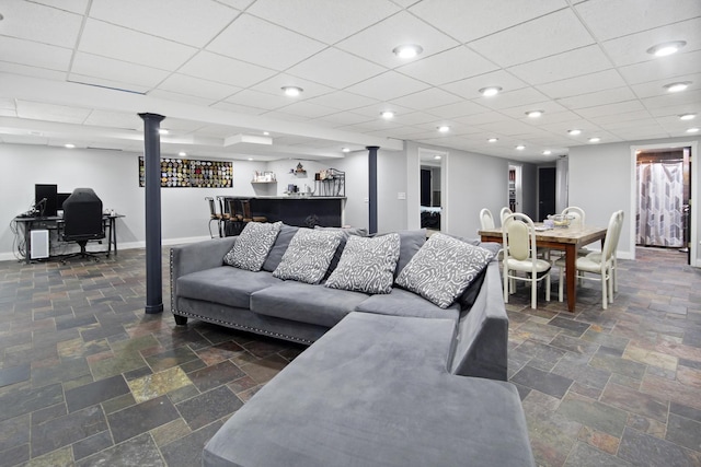 living room with recessed lighting, baseboards, a bar, and stone tile flooring