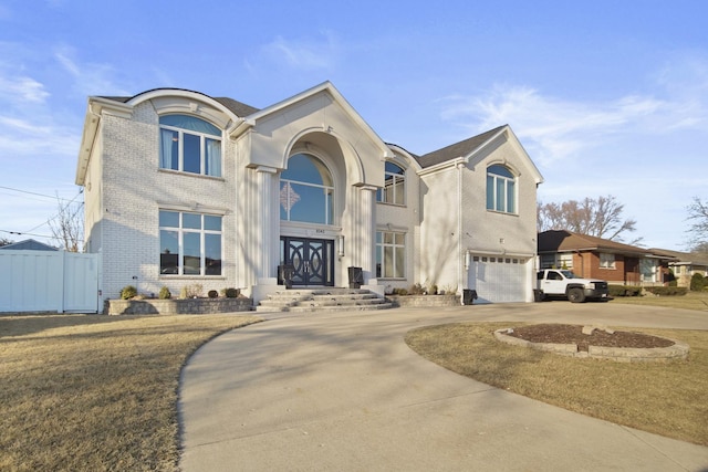 view of front of house with brick siding, driveway, a garage, and fence