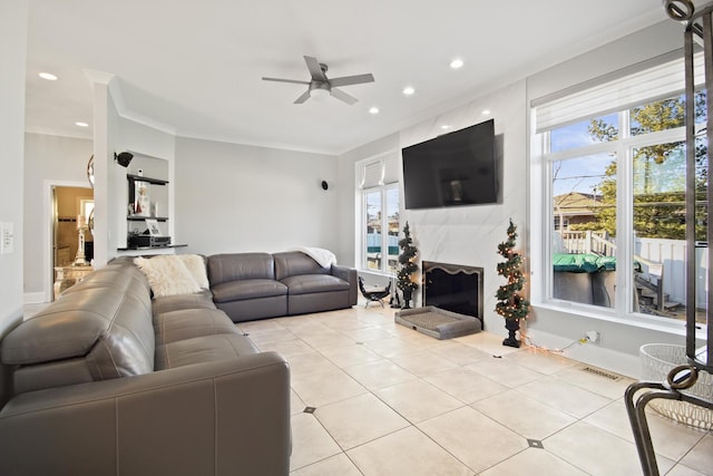 living room featuring crown molding, recessed lighting, a ceiling fan, and a high end fireplace