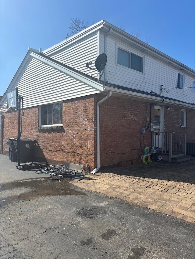 view of side of home featuring brick siding