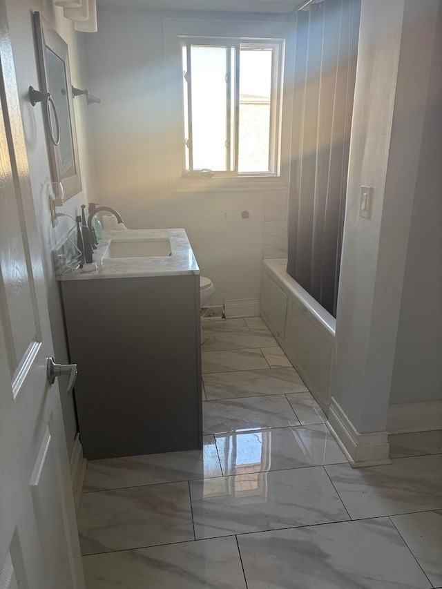 full bath featuring vanity, baseboards, toilet, marble finish floor, and shower / tub combo with curtain