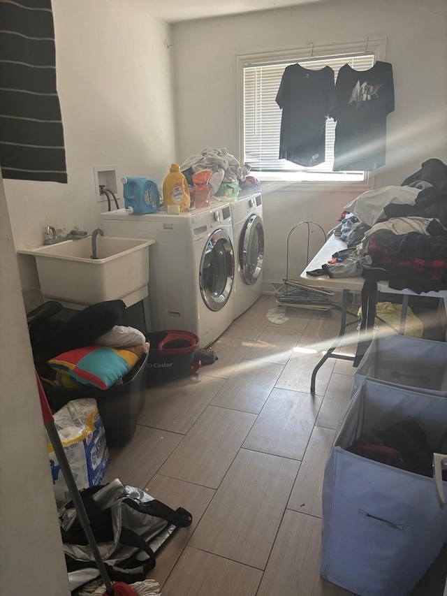 washroom featuring a sink, washing machine and dryer, wood tiled floor, and laundry area