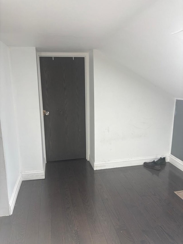 bonus room featuring baseboards, dark wood finished floors, and vaulted ceiling