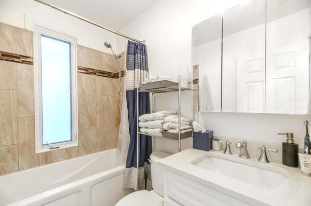 full bath featuring vanity, toilet, and shower / bathtub combination with curtain