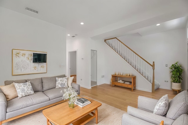 living room with visible vents, baseboards, stairway, recessed lighting, and light wood-style flooring