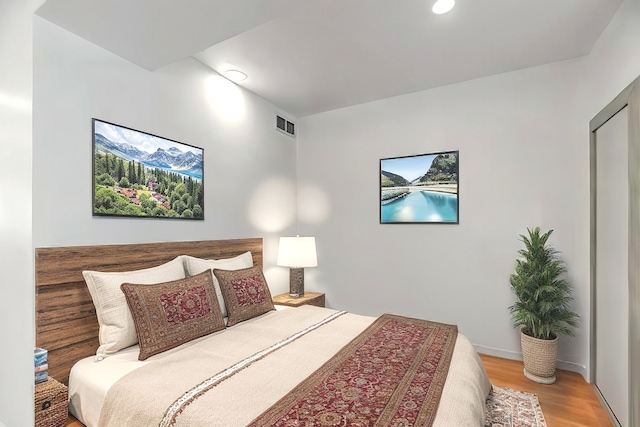 bedroom with recessed lighting, wood finished floors, visible vents, and baseboards