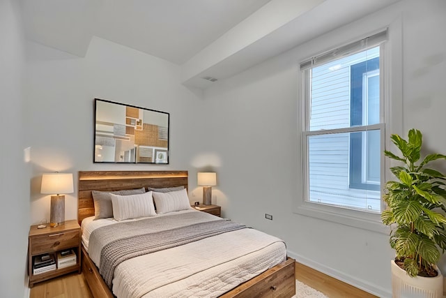 bedroom featuring baseboards and light wood finished floors