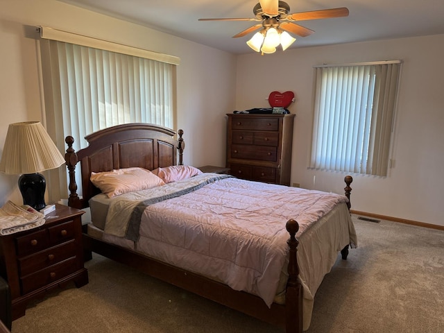 carpeted bedroom featuring visible vents, a ceiling fan, and baseboards