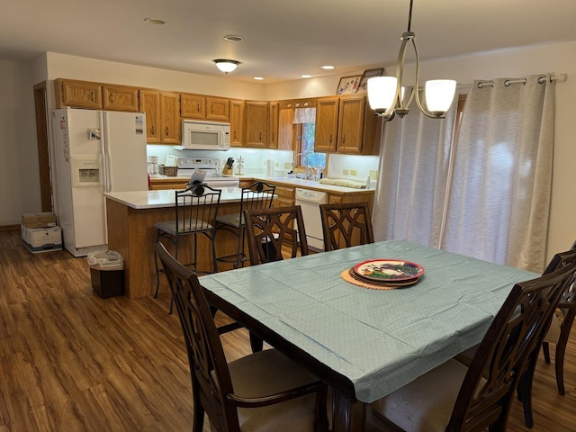 dining space featuring a notable chandelier, recessed lighting, and dark wood-style flooring