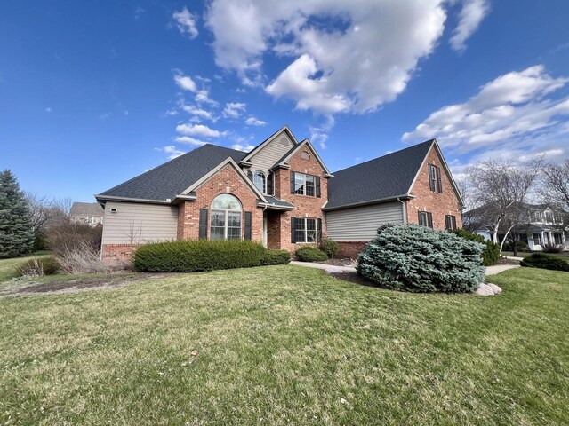 1904 Mullikin Dr, Champaign, IL 61822 - traditional-style house featuring a shingled roof, a front yard, and brick siding