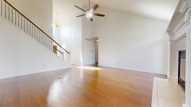 1904 Mullikin Dr, Champaign, IL 61822 - unfurnished living room with light wood finished floors, stairs, a fireplace with flush hearth, and a ceiling fan