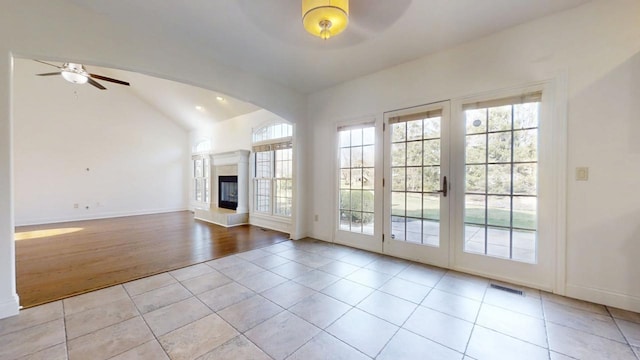 1904 Mullikin Dr, Champaign, IL 61822 - unfurnished living room featuring visible vents, ceiling fan, lofted ceiling, a glass covered fireplace, and tile patterned flooring