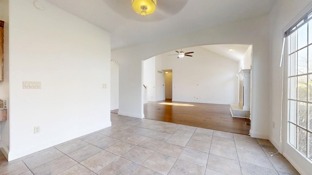 1904 Mullikin Dr, Champaign, IL 61822 - unfurnished room featuring light tile patterned flooring, baseboards, a ceiling fan, arched walkways, and lofted ceiling