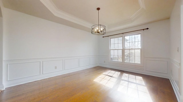 1904 Mullikin Dr, Champaign, IL 61822 - spare room featuring a wainscoted wall, a chandelier, a raised ceiling, wood finished floors, and ornamental molding