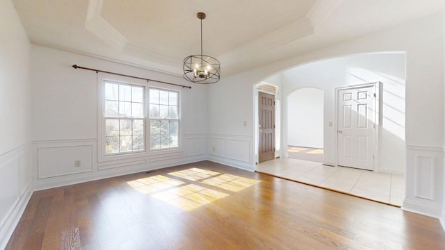 1904 Mullikin Dr, Champaign, IL 61822 - spare room with a chandelier, arched walkways, a decorative wall, and a raised ceiling