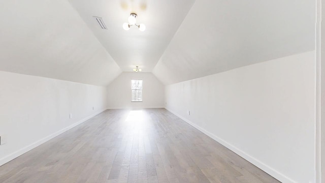1904 Mullikin Dr, Champaign, IL 61822 - additional living space with baseboards, vaulted ceiling, visible vents, and light wood-style floors
