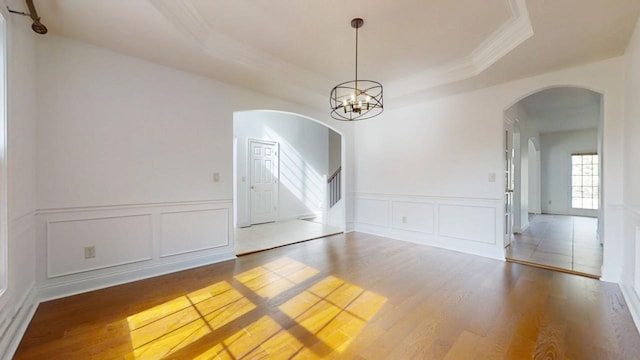 1904 Mullikin Dr, Champaign, IL 61822 - unfurnished room featuring arched walkways, a tray ceiling, and wood finished floors