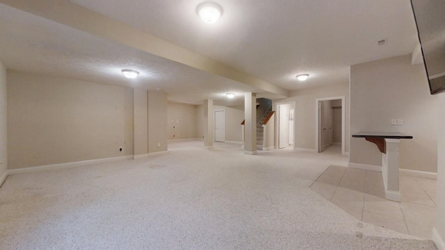 1904 Mullikin Dr, Champaign, IL 61822 - finished below grade area featuring light tile patterned flooring, baseboards, stairway, and a textured ceiling