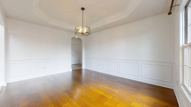 1904 Mullikin Dr, Champaign, IL 61822 - spare room with crown molding, wood finished floors, arched walkways, a tray ceiling, and an inviting chandelier