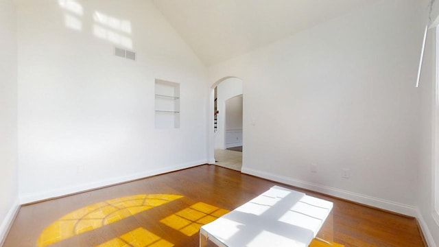 1904 Mullikin Dr, Champaign, IL 61822 - spare room featuring arched walkways, visible vents, built in shelves, and wood finished floors