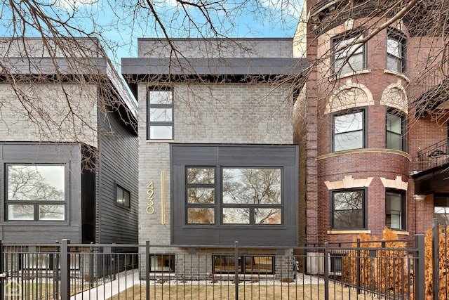 view of front facade with a fenced front yard and brick siding