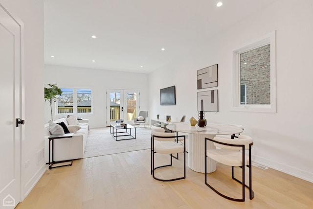 living room featuring light wood finished floors, visible vents, recessed lighting, and baseboards