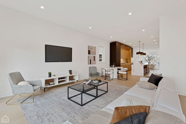 living area with recessed lighting, light wood-style flooring, and baseboards