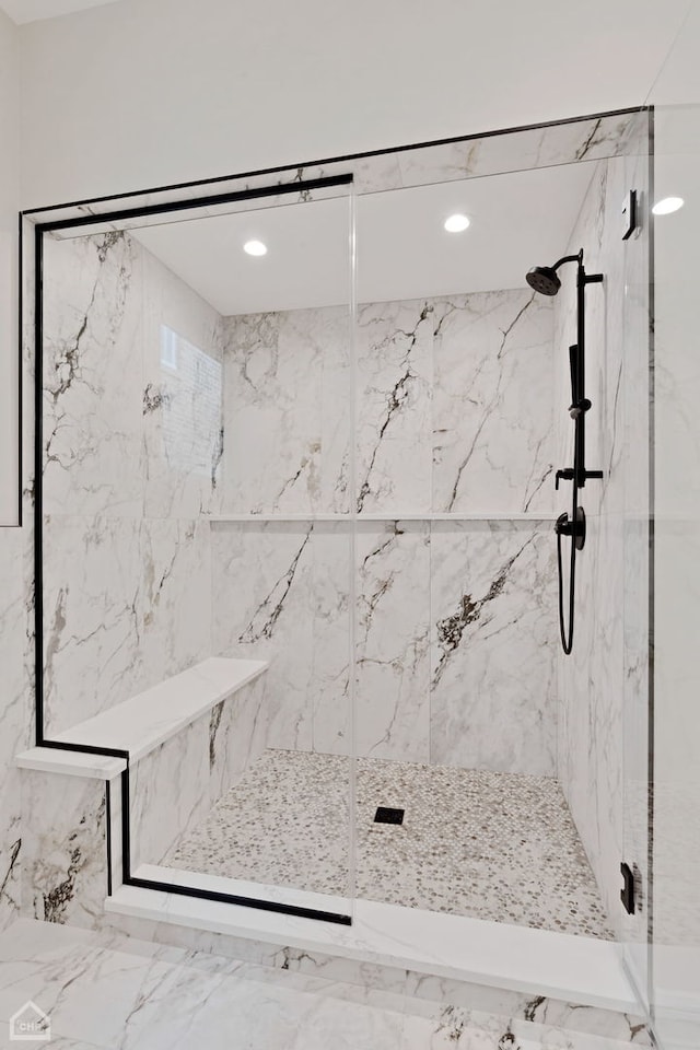 bathroom with a marble finish shower and recessed lighting