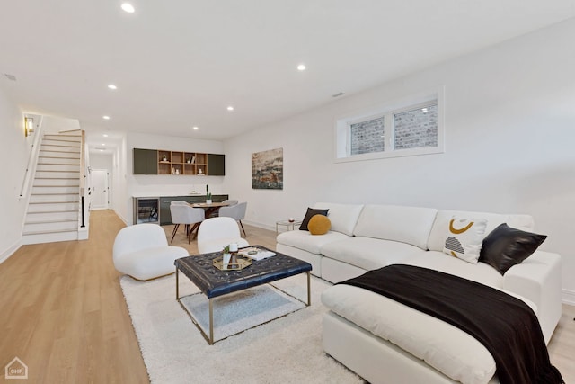 living area with bar area, beverage cooler, stairs, recessed lighting, and light wood-style floors