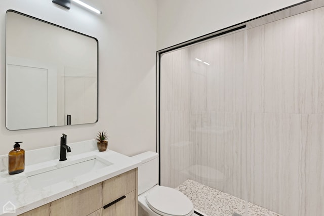 bathroom with tiled shower, toilet, and vanity