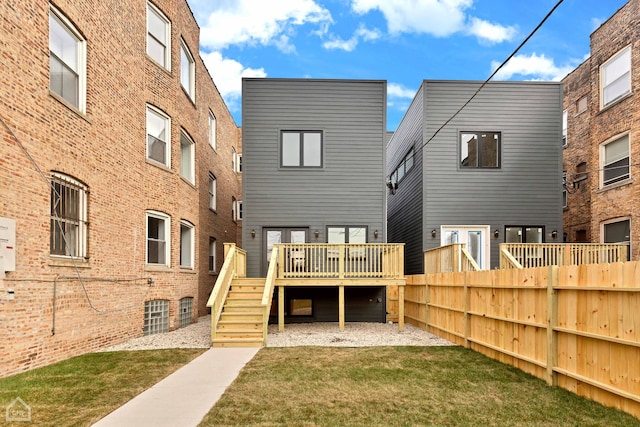 back of house featuring a lawn, a deck, stairs, and fence