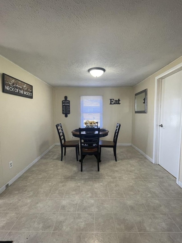 dining area with baseboards and a textured ceiling