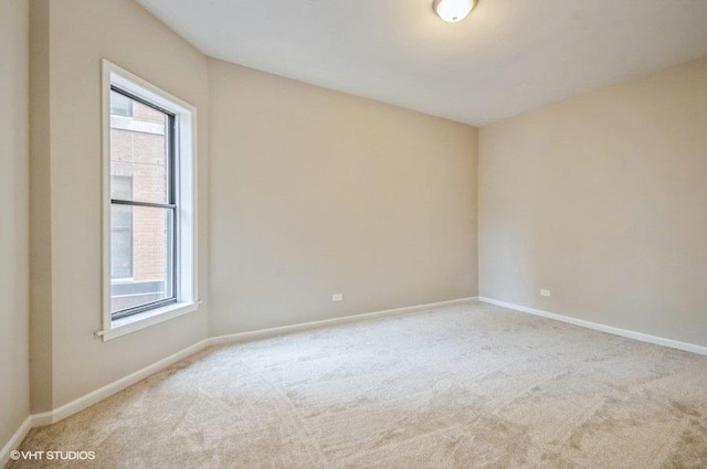 carpeted empty room featuring plenty of natural light and baseboards