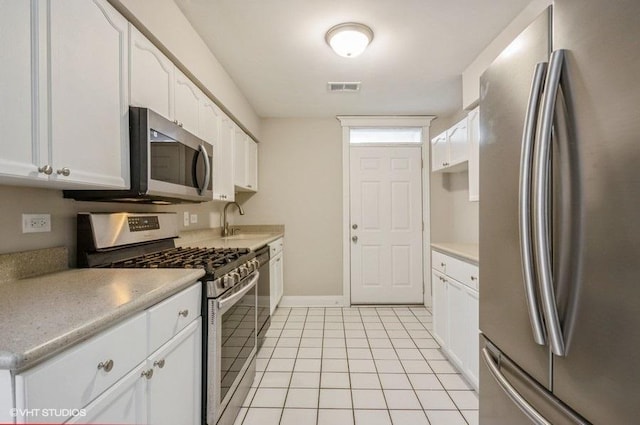 kitchen with visible vents, light tile patterned flooring, a sink, white cabinets, and appliances with stainless steel finishes